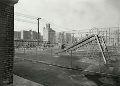 an abandoned playground in the middle of a city with tall buildings and power lines behind it