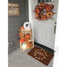 the front door is decorated with fall leaves and pumpkins