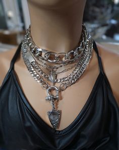 This handmade chunky stainless steel chain layered necklace set is a stunning piece of jewelry that is perfect for those who love bold and edgy accessories. This is two necklaces, the big chunky choker that is adjustable with a built-in extender, and the 4-strand drop festoon design necklace (also adjustable). Adding depth and dimension to the piece is a u lock and arrowhead pendant. Very punk, grunge aesthetic! All the chains are made of sturdy stainless steel, ensuring durability and longevity, and making it completely hypoallergenic, waterproof, and non tarnish. It will look exactly like this forever!  This necklace set is an excellent handmade gift for someone special. It is a perfect choice for those who love alternative and goth styles, as well as anyone who wants to make a statement Goth Layered Necklaces, Silver Chain For Women Unique, Grunge Jewelry Aesthetic, Punk Grunge Aesthetic, Choker Necklace Outfit, Goth Styles, Grunge Chokers, Arrowhead Pendant, Handmade Aesthetic