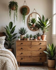 a bedroom with potted plants on the dresser