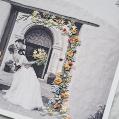 an old photo with flowers on it and a wedding couple holding each other's hands