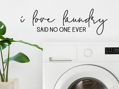 a white washer sitting next to a green plant