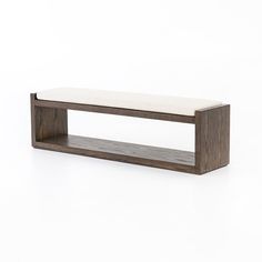 a wooden shelf with a white cushion on top