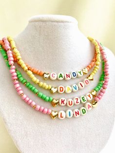 "Welcome to our vibrant and joyful personalized name necklace collection! Our colorful necklaces are perfect for children and make for a wonderful kids' birthday gift, designed to bring smiles to their faces. With six stunning color options to choose from, each necklace is a unique masterpiece. Crafted with colorful beads and adorned with Mother of Pearl letters that spell out a custom name, these necklaces are truly one of a kind. Make your little one's day special by gifting them a personalized name necklace that reflects their unique personality and style. Whether it's for a birthday, a special occasion, or just to show your love, these necklaces are sure to be cherished keepsakes.\" HOW TO ORDER ? 1- Choose the letter quantity of the name/word/phrase/initials you want. 2- Find the righ Cute Personalized Multicolor Charm Necklaces, Trendy Personalized Necklace For Birthday, Trendy Personalized Jewelry For Birthday, Customized Cute Multicolor Jewelry, Customized Multicolor Cute Jewelry, Trendy Customizable Necklaces For Personalized Gifts, Customizable Trendy Necklaces For Personalized Gifts, Cute Multicolor Customized Jewelry, Trendy Customizable Necklace For Personalized Gifts