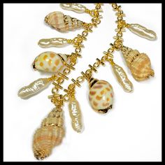 "This classy piece is made with:  ~Hand gold leaf painting ~Bali shells ~Gold novelty chain ~Long faux freshwater  pearls ~16\" length with lobster clasp and adjustment chain." Gold Pearl Shell Necklace Handmade, Handmade Gold Shell Necklace With Pearl, Handmade Gold Shell Necklace With Pearls, Gold Shell Jewelry With Pearl Chain, Gold Pearl Shell Necklace With Pearl Drop, Gold Shell Pearl Chain Jewelry, Handmade Gold Shell Pearl Necklace, Elegant Gold Shell With Lobster Clasp, Gold Shell Necklace With Pearl Chain