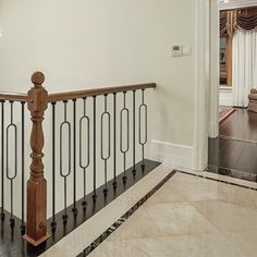 a staircase with railings and wooden handrails in a large home's entryway