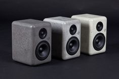 three concrete speakers sitting next to each other