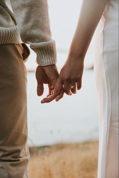 two people holding hands while standing next to each other