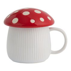 a red and white mushroom shaped coffee cup with polka dots on the top, sitting in front of a white background