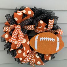 an orange and black football wreath with polka dots