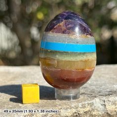 a marble ball sitting on top of a rock next to a yellow block