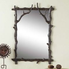 a mirror sitting on top of a wooden table next to a clock and other items