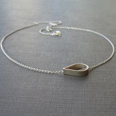 A single open teardrop in sterling silver floats freely across a small but sturdy sterling silver chain. A necklace simple enough for everyday and special enough for evening. The teardrop measures 1/2 inch across. Choose your necklace length from the drop-down menu; the necklace pictured on the model is 16 inches long. Silver Teardrop Necklace With Delicate Chain, Modern Sterling Silver Teardrop Pendant Necklace, Modern Sterling Silver Teardrop Drop Necklace, Minimalist Silver Long Drop Necklace, Silver Drop Necklace With Delicate Chain And Teardrop Pendant, Silver Teardrop Drop Necklace With Silver Chain, Silver Drop Necklace With Teardrop Pendant, Teardrop Silver Chain Necklace As Gift, Silver Minimalist Drop Necklace As A Gift