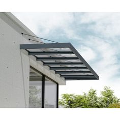 an awning on the side of a building with trees and sky in the background