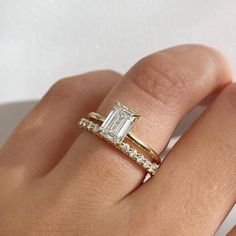 a woman's hand with a gold ring and diamond engagement band on it,