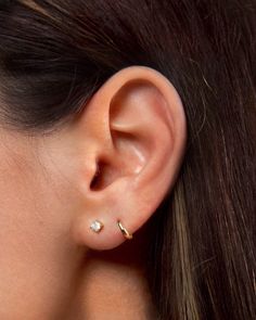 a woman's ear with a single diamond in the middle and two small diamonds on each side