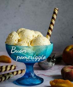 a blue bowl filled with ice cream next to sliced peaches