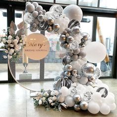 balloons and flowers are arranged in the shape of a christmas tree at macy's bridal showroom