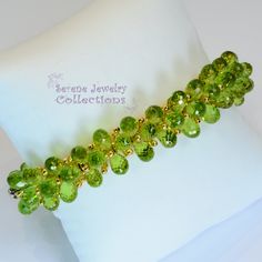 Italian made Green Peridot bead 18k yellow gold bracelet! Many 18k gold balls are scattered throughout the bracelet in between the peridot beads. A small white gold clasp completes the bracelet. There is one small 3 pointer diamond on the clasp. Total Weight: 54 grams Bracelet length: 7 inches Precious Metal: 18k yellow gold Precious stones: -Peridot Teardrops 9mmx5.2mm -White Round Diamonds: 0.03 carat, QTY 1 (on the clasp) Hallmark: 750 Green Faceted Bead Bangle Jewelry, Elegant Lime Green Jewelry With Round Beads, Elegant Lime Green Beaded Jewelry, Green Faceted Beads Bangle, Elegant Peridot Round Beads Jewelry, Peridot Gemstone Beads Jewelry, Yellow Gold Peridot Jewelry With Polished Finish, Gold Peridot Jewelry With Polished Finish, Elegant Lime Green Faceted Jewelry