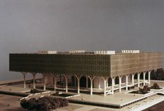 an architectural model of a building with columns and arches on the roof, in front of a cloudy sky