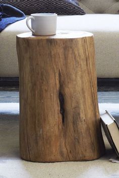 a coffee cup sitting on top of a wooden stump