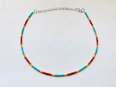 This sunset themed necklace is made with turquoise, yellow, orange, and red glass seed beads to create a cool sunset effect. It comes in four different lengths (14, 16, 18, or 20 inches) and each necklace also comes with three additional inches of extender chain. This summer necklace brings out the Colorful Beaded Hippie Jewelry, Handmade Southwestern Necklace For Beach, Southwestern Multicolor Beaded Necklaces For Beach, Southwestern Style Multicolor Beaded Necklaces For Beach, Southwestern Style Multicolor Beaded Necklace For Beach, Colorful Hippie Round Bead Jewelry, Hippie Style Colorful Round Bead Jewelry, Red Adjustable Necklace For Vacation, Adjustable Red Necklace For Vacation