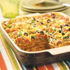 an enchilada casserole with black olives, peppers and cheese