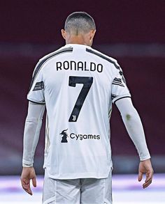 a soccer player with his back turned to the camera, wearing white and black uniform