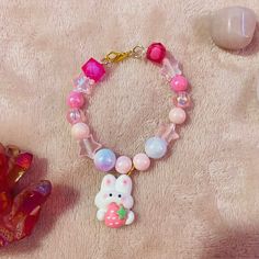 Kawaii cute pastel bracelet with strawberry bunny charm! Kawaii Adjustable Pink Beaded Bracelet, Pink Adjustable Kawaii Beaded Bracelets, Adjustable Pink Beaded Bracelet In Kawaii Style, Adjustable Pink Beaded Bracelets In Kawaii Style, Adjustable Pink Kawaii Charm Bracelet, Handmade Pink Casual Charm Bracelet, Handmade Pink Charm Bracelet, Handmade Pink Charm Bracelet Casual Style, Playful Pink Jewelry For Easter