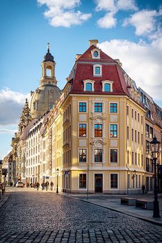 an old european building in the middle of a cobblestone street