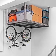 there is a bike hanging on the wall next to some boxes and other things in it