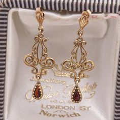 The gemstones in the jewellery are all natural stones. We do not sell jewellery containing manmade, synthetic or laboratory grown stones. This stunning pair of Victorian design ornate vintage drop earrings has been beautifully crafted in 9 carat yellow gold, each earring having a teardrop/pear cut garnet bead set hanging from the scrolled design. A perfect anniversary or birthday gift. Hallmark - The earrings do not have any hallmarks but have been tested and present as 9ct gold. Weight - 1.6g ( Gold Earrings Vintage, Victorian Gold Jewelry, Vintage Earrings Victorian, Victorian Gold Earrings, October Jewelry, Victorian Drop Earrings, Ornate Jewelry, Victorian Jewellery, Vintage Gold Earrings