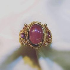 18K Yellow Gold Luxury Ruby Ring With Cabochon Cut, Luxury Oval Cabochon Ruby Ring, Luxury Cabochon Ruby Ring For Anniversary, Gold Ruby Rings With Intricate Design, Luxury Collectible Sapphire Ring, Gold Ruby Ring Oval Cabochon With Polished Finish, Traditional Gold Oval Ruby Ring, Traditional Oval Ruby Ring In Gold, Ceremonial Gold Ruby Ring With Intricate Design