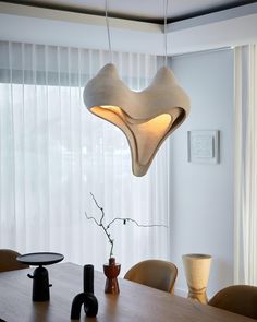 a dining room table with chairs and a light fixture hanging from the ceiling