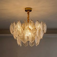 a chandelier with leaves hanging from it's ceiling in a living room