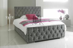 a bedroom with white floors and gray upholstered bed