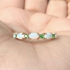 Opal and Emerald Half Eternity Band Ring. MaterialSolid Gold (14K/18K) or Platinum 950 FinishingHigh Polished/Shiny PlatingRhodium/Platinum Family (Only if white gold selected) FitStandard Width3.2 mm Height3 mm SettingProng Stone #1Natural Opal ShapeOval Size3mm x 5mm Quantity5 Opals ColorWhite with Fire-like hues of Orange, Yellow and Red Stone #2Natural Emerald QualityAAA CutRound, Diamond Cut Size2mm Quantity4 Emeralds Click below to add laser engraving. https://www.etsy.com/listing/63107091 Oval 14k Gold Eternity Band, Oval Yellow Gold Emerald Ring With Multiple Stones, Oval Yellow Gold Emerald Ring With Multi-stone, Heirloom Oval Opal Ring For Anniversary, Oval Halo Jewelry For Anniversary, Oval White Gold Birthstone Ring For Wedding, Oval Multi-stone Yellow Gold Birthstone Ring, White Oval Stackable Rings For Anniversary, White Hallmarked Birthstone Wedding Ring