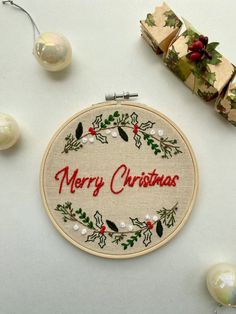 a cross stitch christmas ornament surrounded by presents