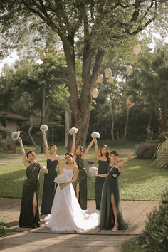 a group of women standing next to each other in front of a tree with paper balls