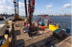 an oil drilling rig on the deck of a boat in the water with other equipment around it