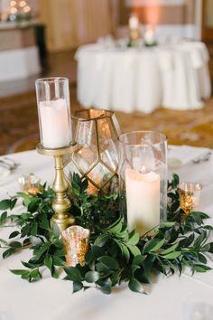 the table is set with candles and greenery