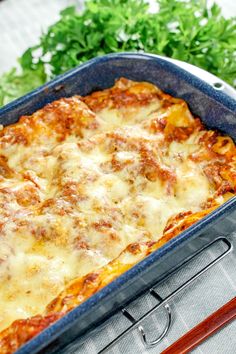 a casserole dish with cheese and parsley on the side