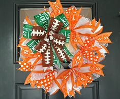 an orange and white football wreath on a door