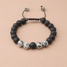 This handmade wax cord bracelet features Dalmatian Jasper and lava stones. Dalmation Jasper is a stone of action, calming the overactive mind while also promoting motivation and enthusiasm. It is known to encourage a child-like joy and energy, as well as reflection and self-examination. Lava Beads are made from Natural Volcanic Basalt. The lava stones acts as a sponge-like carrier as it soaks up your oils and retains them in the core of the Bead. Casual Everyday Lava Stone Beaded Bracelets, Casual Lava Stone Beaded Bracelets For Everyday, Casual Lava Stone Bracelet With Natural Stones, Casual Adjustable Lava Stone Beaded Bracelets, Casual Adjustable Lava Stone Jewelry, Handmade Casual Braided Bracelets For Meditation, Adjustable Lava Stone Beaded Bracelets, Casual Lava Stone Beaded Bracelets As Gift, Casual Braided Bracelets With 8mm Beads As Gift