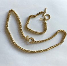 This is a vintage gold tone metal Jones of New York necklace and bracelet set. Both necklace and bracelet are made of a double interlocking rope style chain. They have a toggle closure and a Jones of New York hangtag. The necklace is 19 inches long. The bracelet is 7 3/4 inches long. Both of these measurements include the ring for the toggle. The chains are 6mm thick. This item is an excellent preowned vintage condition and appears to have never been worn Vintage Gold Chain Necklace With Toggle Clasp, Vintage Gold Toggle Chain Necklace, Vintage Gold Toggle Necklace With Chunky Chain, Vintage Gold Metal Toggle Necklace, Gold Vintage Toggle Necklace With Chunky Chain, Color Bracelet, Necklace And Bracelet Set, Bracelet And Necklace, Bracelet Vintage