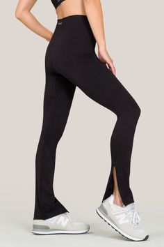 Alala women's seamless flare pant with slit in black Chic Elastane Yoga Pants For Loungewear, Sleek Yoga Pants, Modern Stretch Bottoms For Loungewear, Chic Fitted Workout Bottoms, Modern Fitted High-cut Leg Bottoms, Sleek Stretch Workout Pants, Chic High Stretch Yoga Pants For Workout, Fitted Activewear For Barre, Wide Leg Elastane Leggings For Pilates