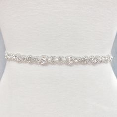 Karla is a captivating pearl bridal belt expertly designed with sparkling crystal rhinestones and pearls to complement your wedding dress. Experience the perfect balance of sophistication and timelessness, adding just the right touch to your bridal ensemble. Embellishment measures approximately 1/2 inch wide Designed with sparkling rhinestones and glistening pearls Available in 17.5 inches with ribbon that measures 106 inches long if you want to tie it in a bow; or 35 inches if you want to attac Elegant Silver Bedazzled Sash, Elegant Silver Bedazzled Sashes, Elegant Bedazzled Silver Sash, Elegant Bedazzled Silver Sashes, Silver Bedazzled Bridal Belt For Wedding, Elegant Bedazzled Bridal Belt For Wedding, Elegant Bedazzled Wedding Sash, Crystal Embellished Bridal Belt, Elegant Silver Bedazzled Bridal Accessories