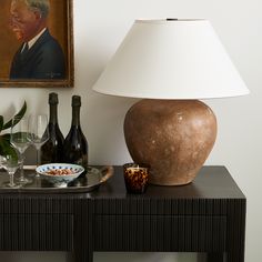 a table topped with a vase next to a lamp