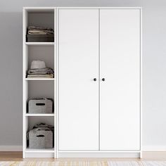 a white closet with two doors and three baskets on the bottom shelf next to it