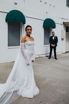 a woman in a wedding dress standing next to a man wearing a tuxedo